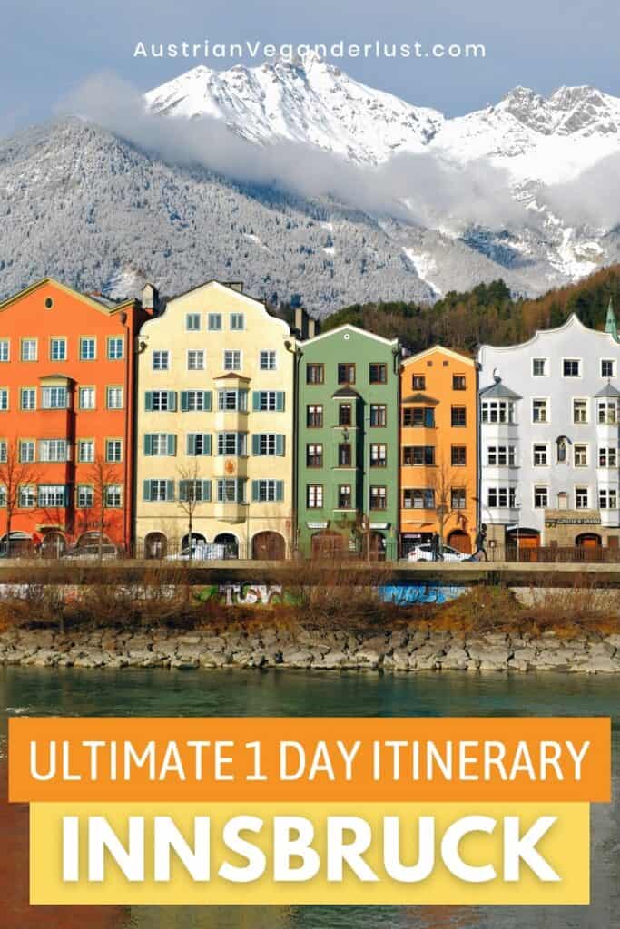 A row of brightly painted historic buildings lines the riverfront in Innsbruck, Austria, with snow-covered Alpine peaks rising dramatically behind them. Bold text reads “Ultimate 1 Day Itinerary – Innsbruck.”