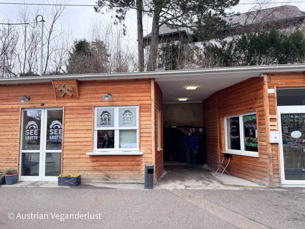 Die mit Holz vertäfelte Kasse und der Haupteingang zur Seegrotte Hinterbrühl, mit „SEE GROTTE“-Schildern an den Fenstern und einem Durchgang, der in das unterirdische Bergwerk führt.