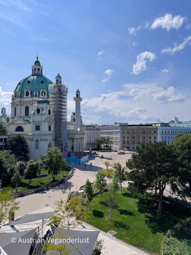 Blick auf die Dachterrasse des Wien Museums. Daneben gibt’s eine Kirche und einen Park.