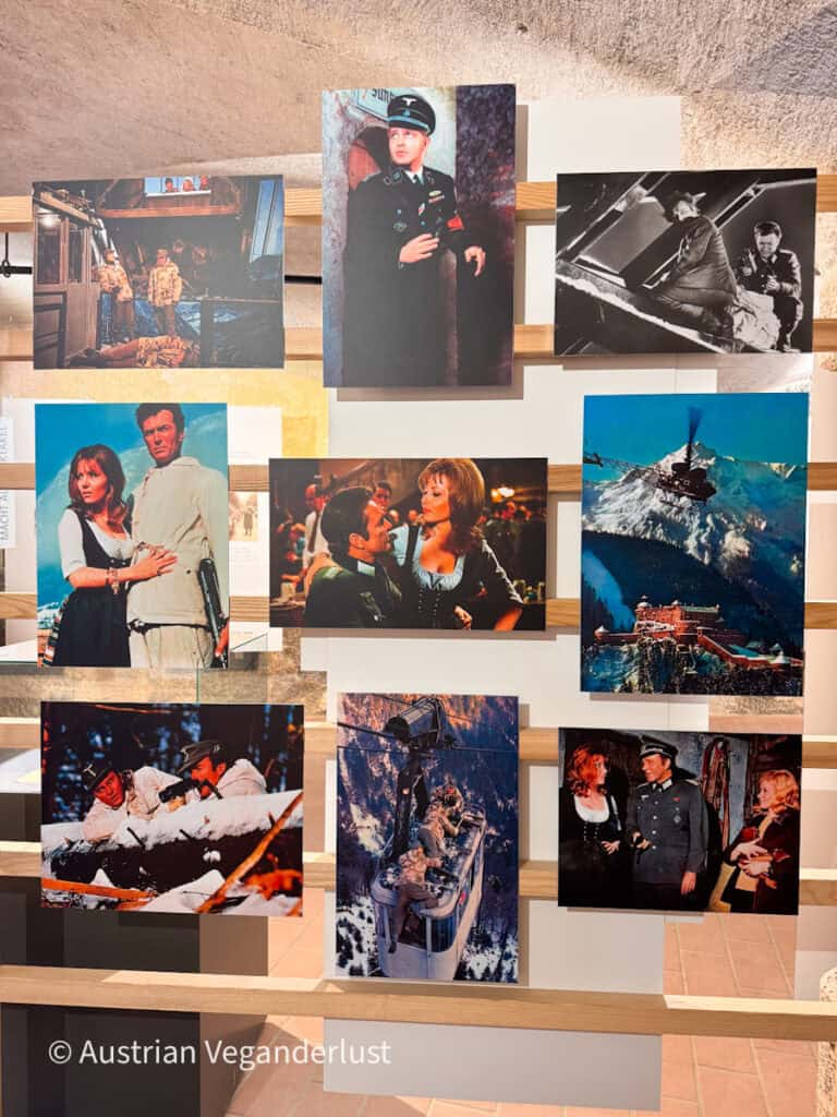Eine Museumsausstellung mit Fotos aus einer Filmproduktion, die in verschneiten Berglandschaften gedreht wurde. Die Sammlung zeigt Schauspieler in Militäruniformen und historischer Kleidung. Ein Hubschrauber über einer Bergfestung. Und Szenen, die auf verschneiten Klippen und in Seilbahnen gedreht wurden.